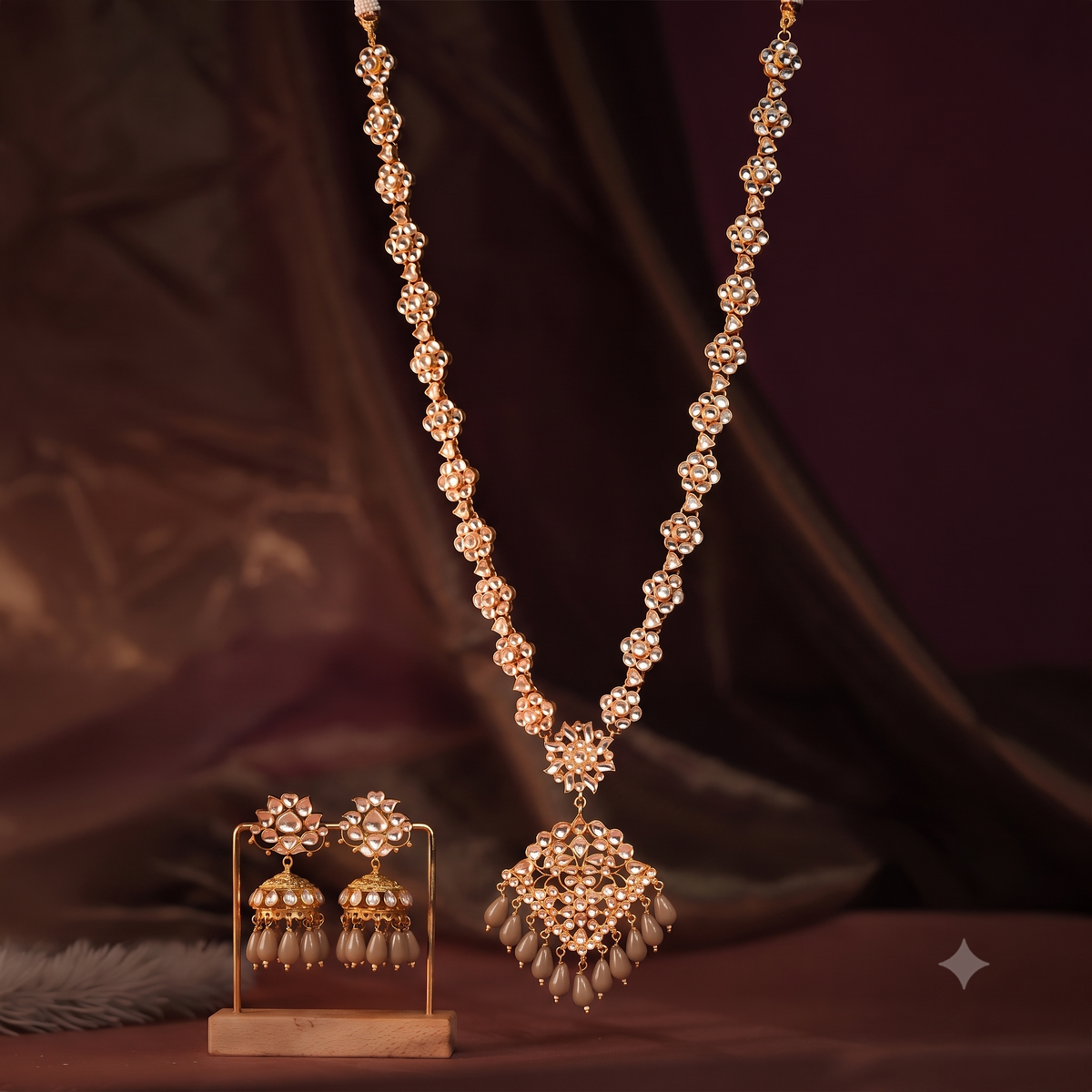 Long floral necklace with pendant design and emerald jhumkis in traditional style