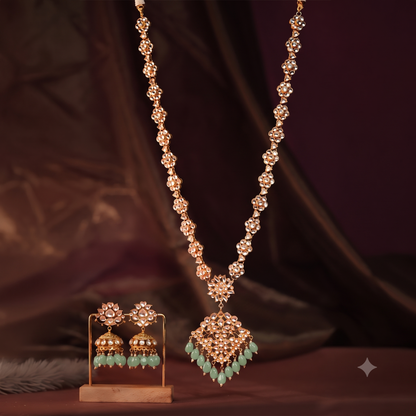 Long floral necklace with pendant design and emerald jhumkis in traditional style